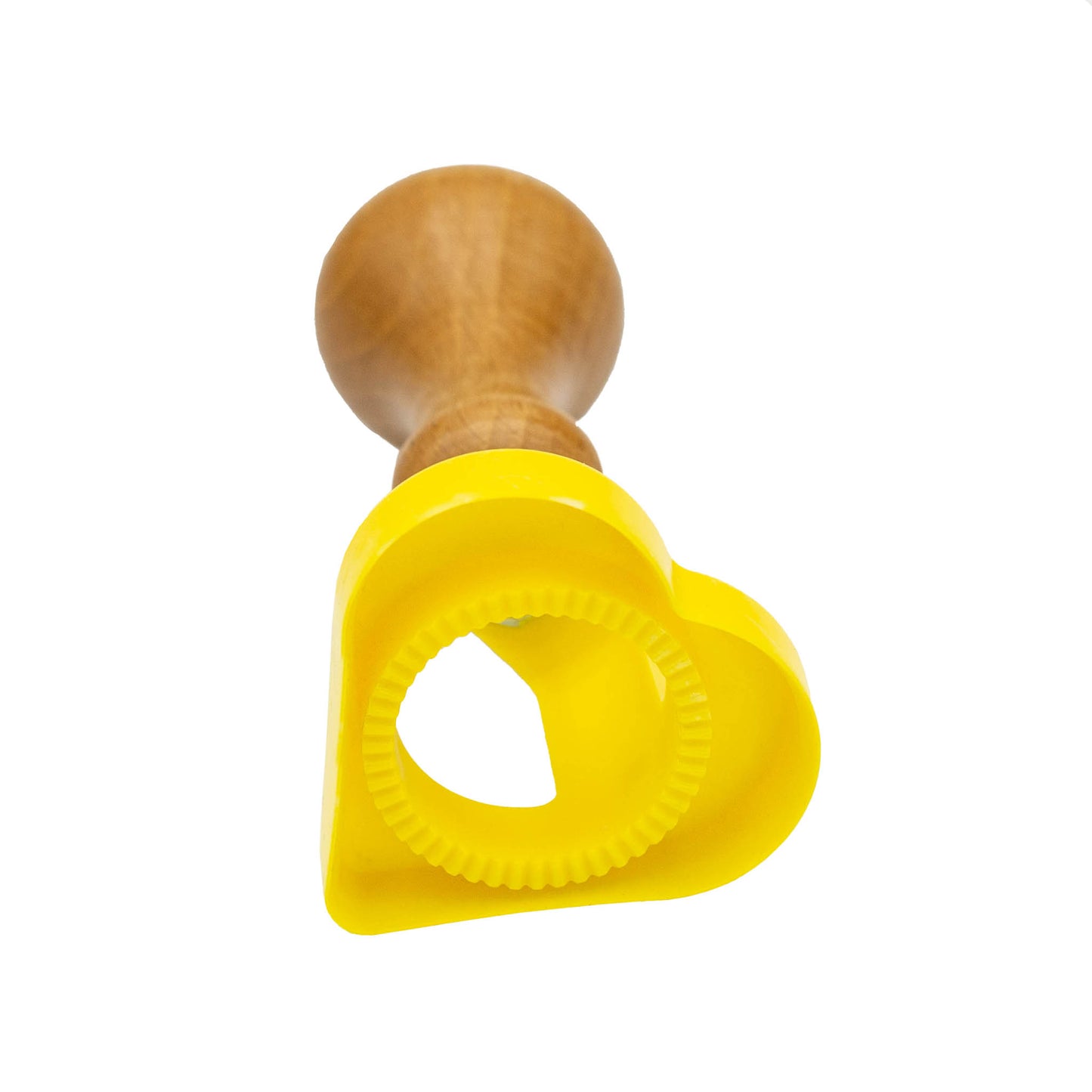 Yellow plastic heart shape biscuit and pasta cutter with wooden handle.