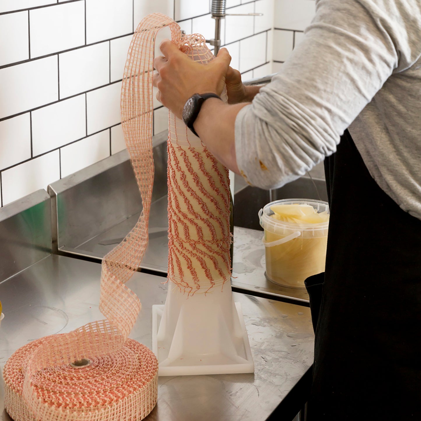 Applying salami netting to a netting applicator tube.